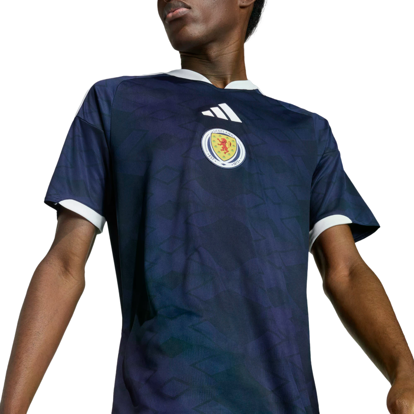 Person wearing a dark blue Adidas Scotland national football team jersey with white trim and a faint diamond pattern, set against a black background.