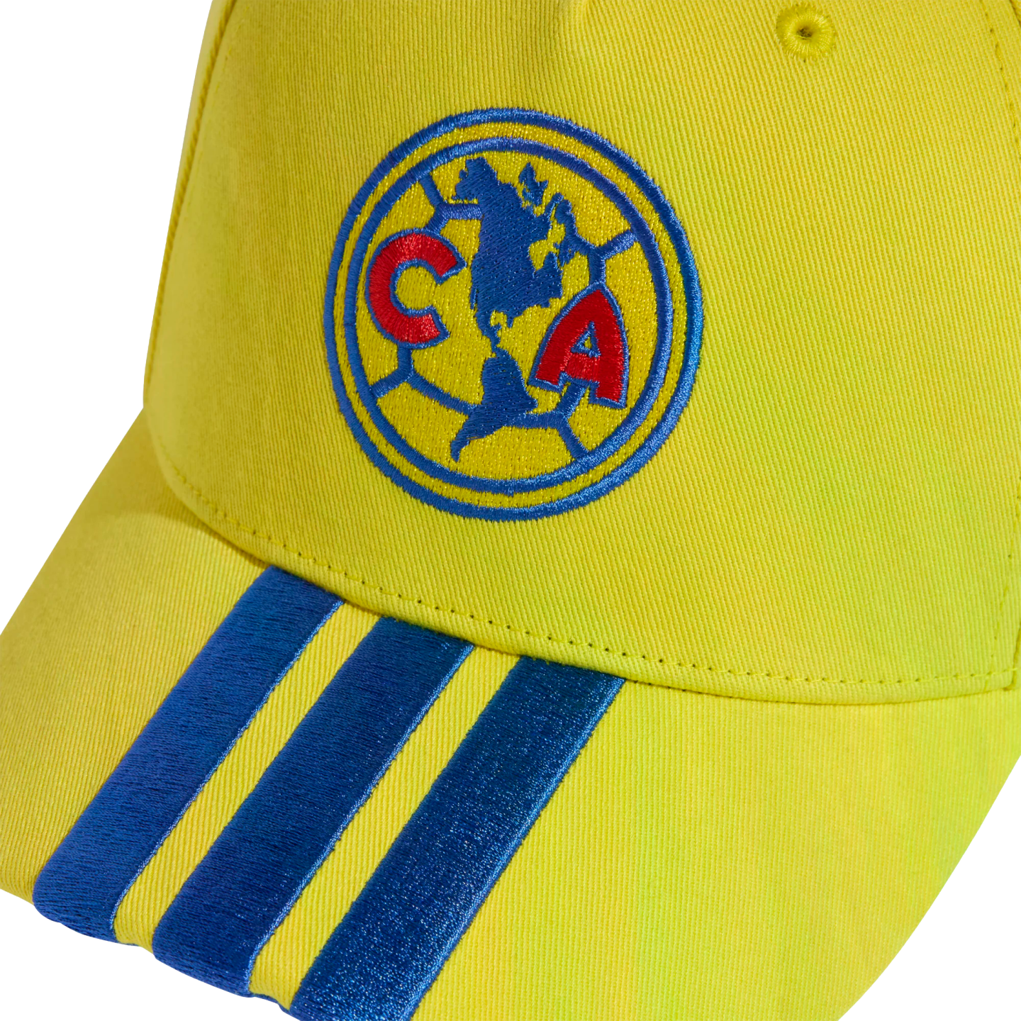 Close-up of a yellow baseball cap with the Club América logo embroidered on the front and three blue stripes on the brim.