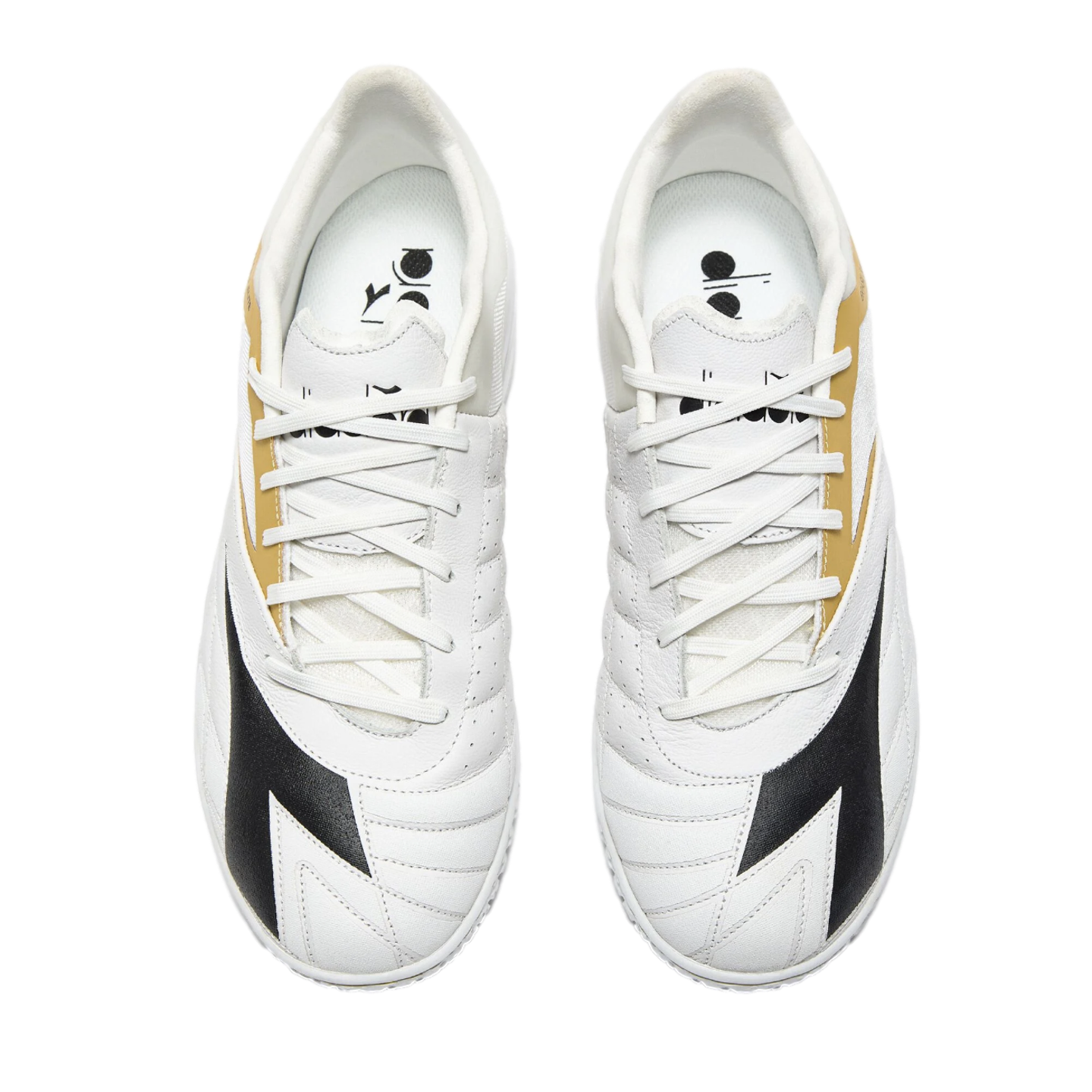 Top-down view of a pair of white Diadora sneakers with black and gold detailing and white laces, set against a solid black background.