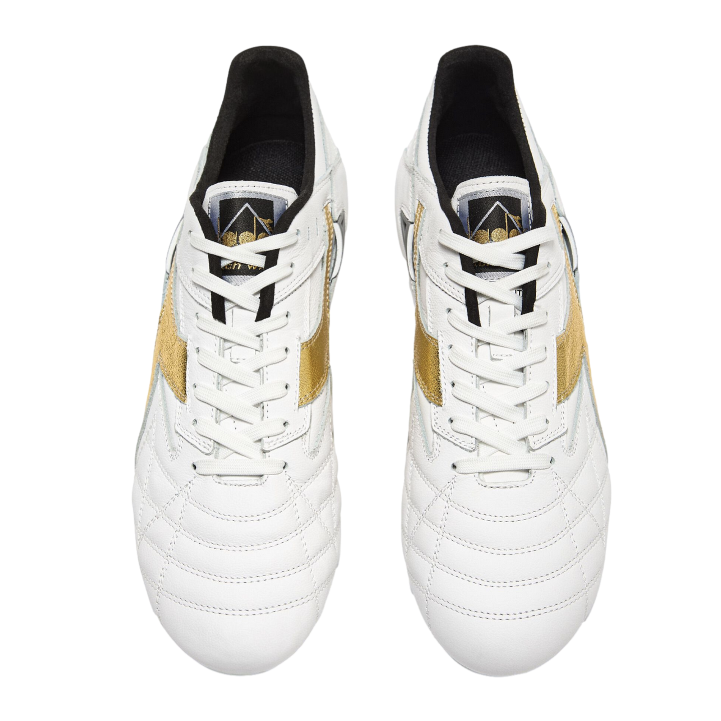 A top-down view of a pair of white leather soccer cleats with metallic gold side stripes and white laces, set against a solid black background.
