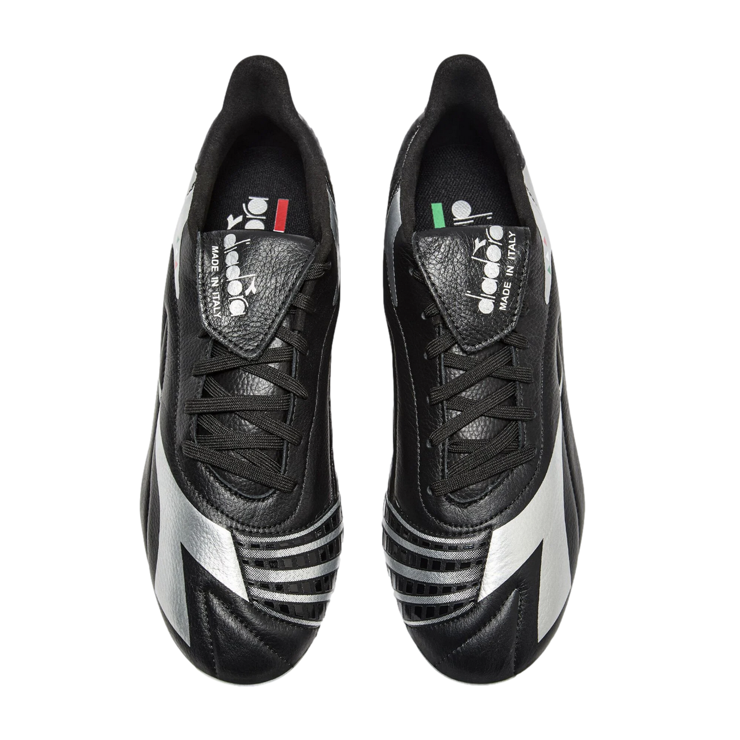 Overhead view of black and silver Diadora soccer cleats with fold-over tongues against a black background.