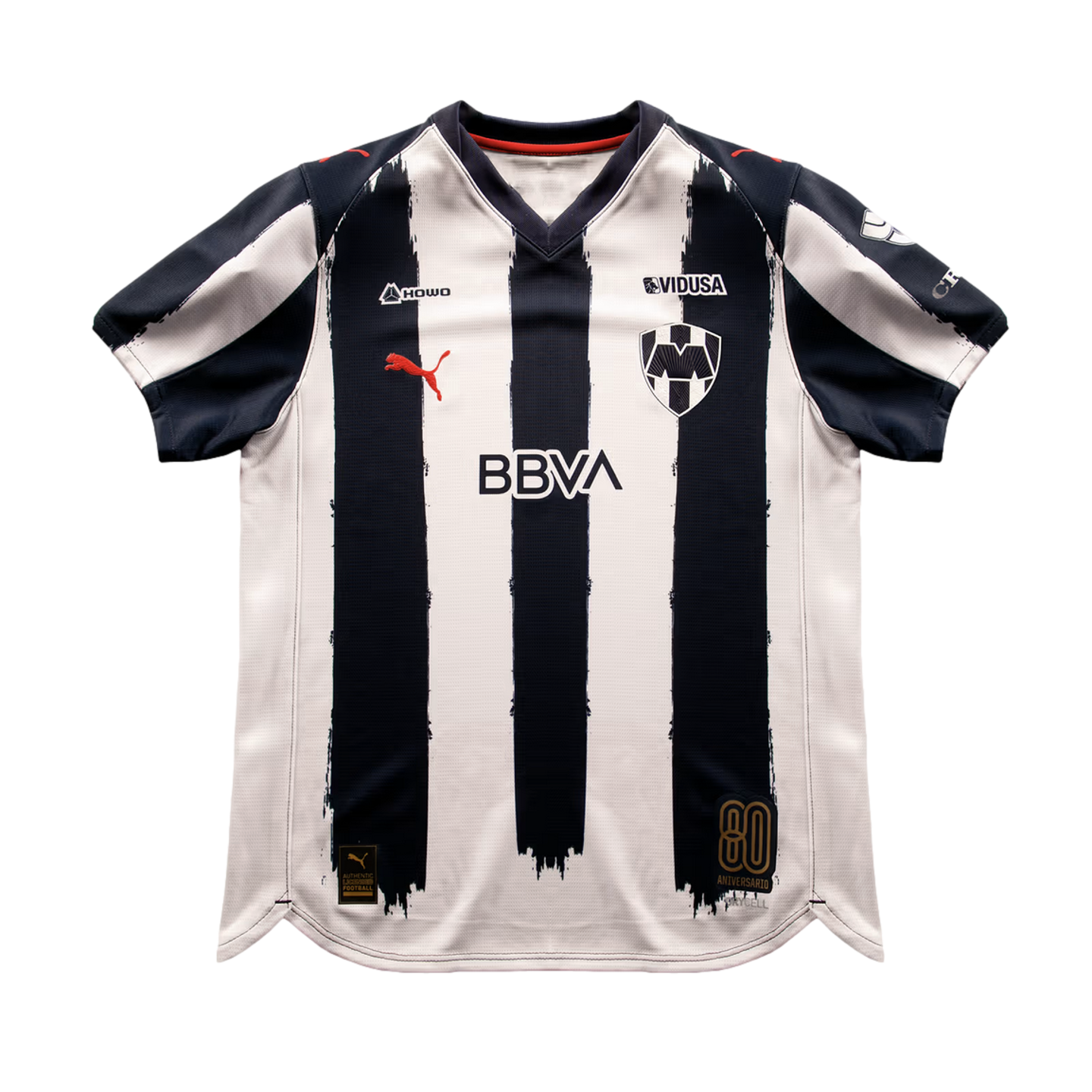 C.F. Monterrey home soccer jersey featuring navy blue and white brush-stroke stripes, red Puma logo, BBVA sponsor, and an 80th-anniversary patch.