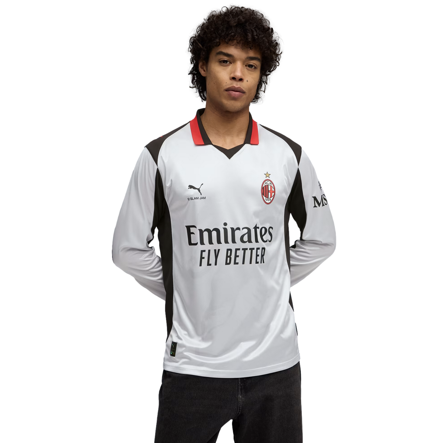 Man in a white AC Milan long-sleeve soccer jersey with red and black accents and 'Emirates Fly Better' logo, against a black background.