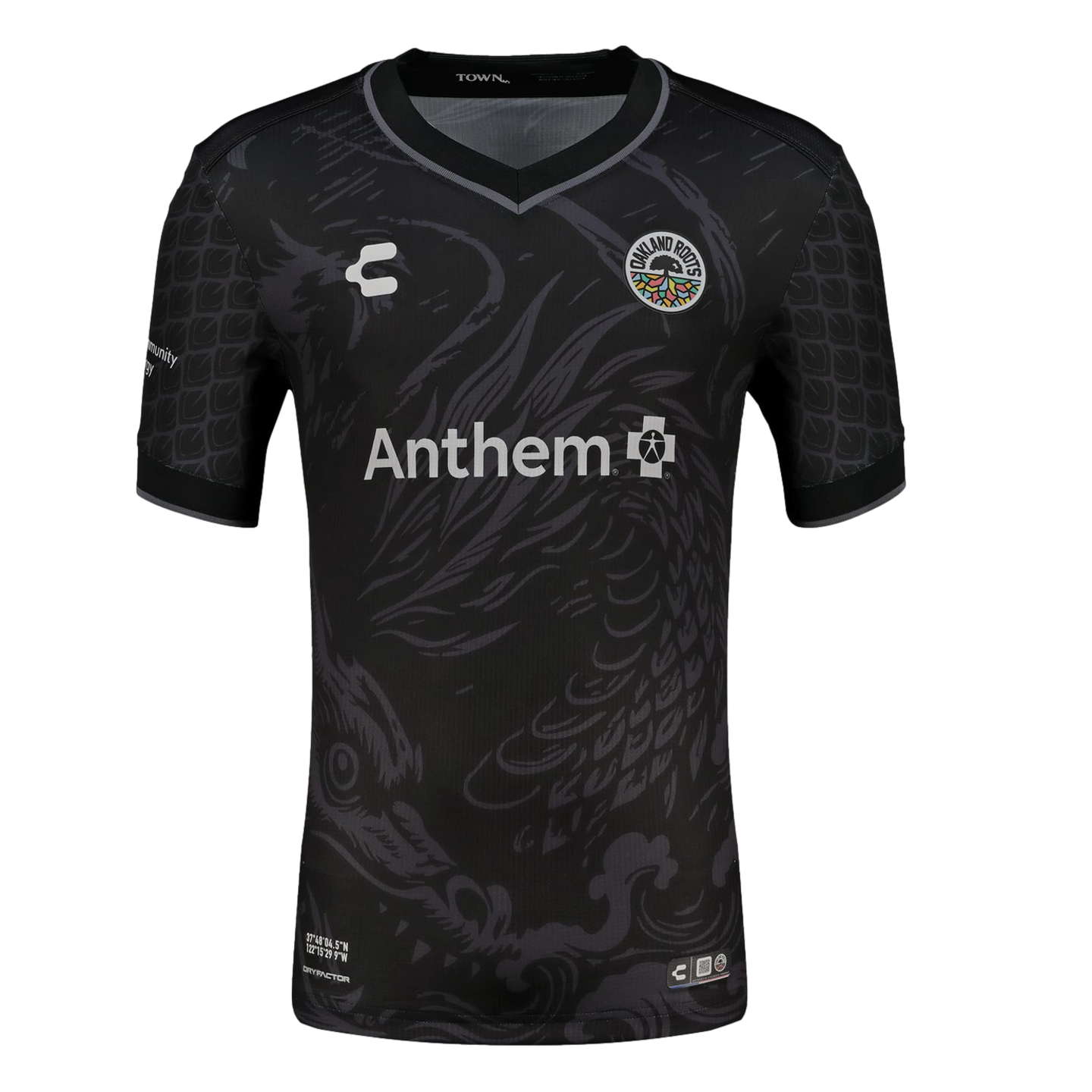 A black short-sleeved soccer jersey featuring a large, subtle grey dragon illustration across the front. The jersey includes the colorful Oakland Roots SC crest on the chest, a white Anthem sponsor logo in the center, and a repeating grey scale pattern on