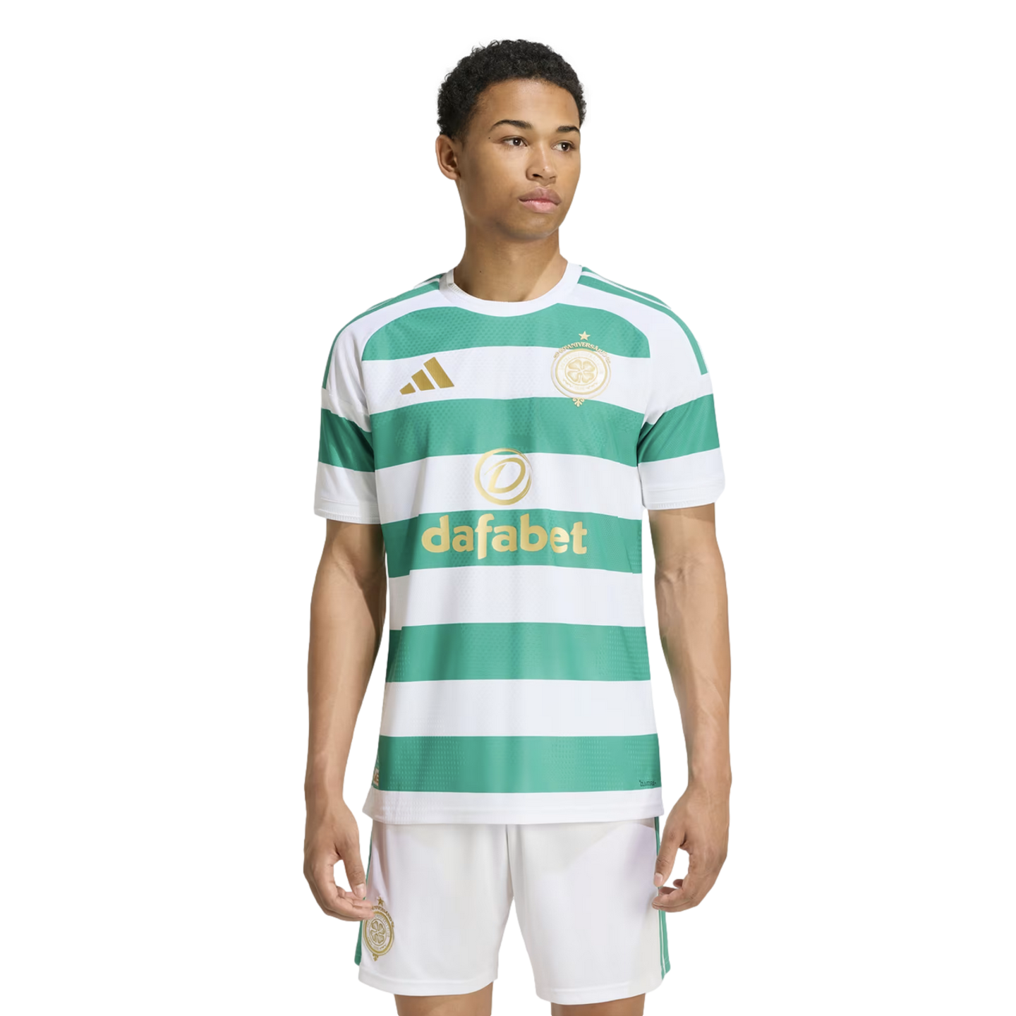 A young man modeling a green and white horizontal striped football jersey with gold logos and matching white shorts against a plain white background.