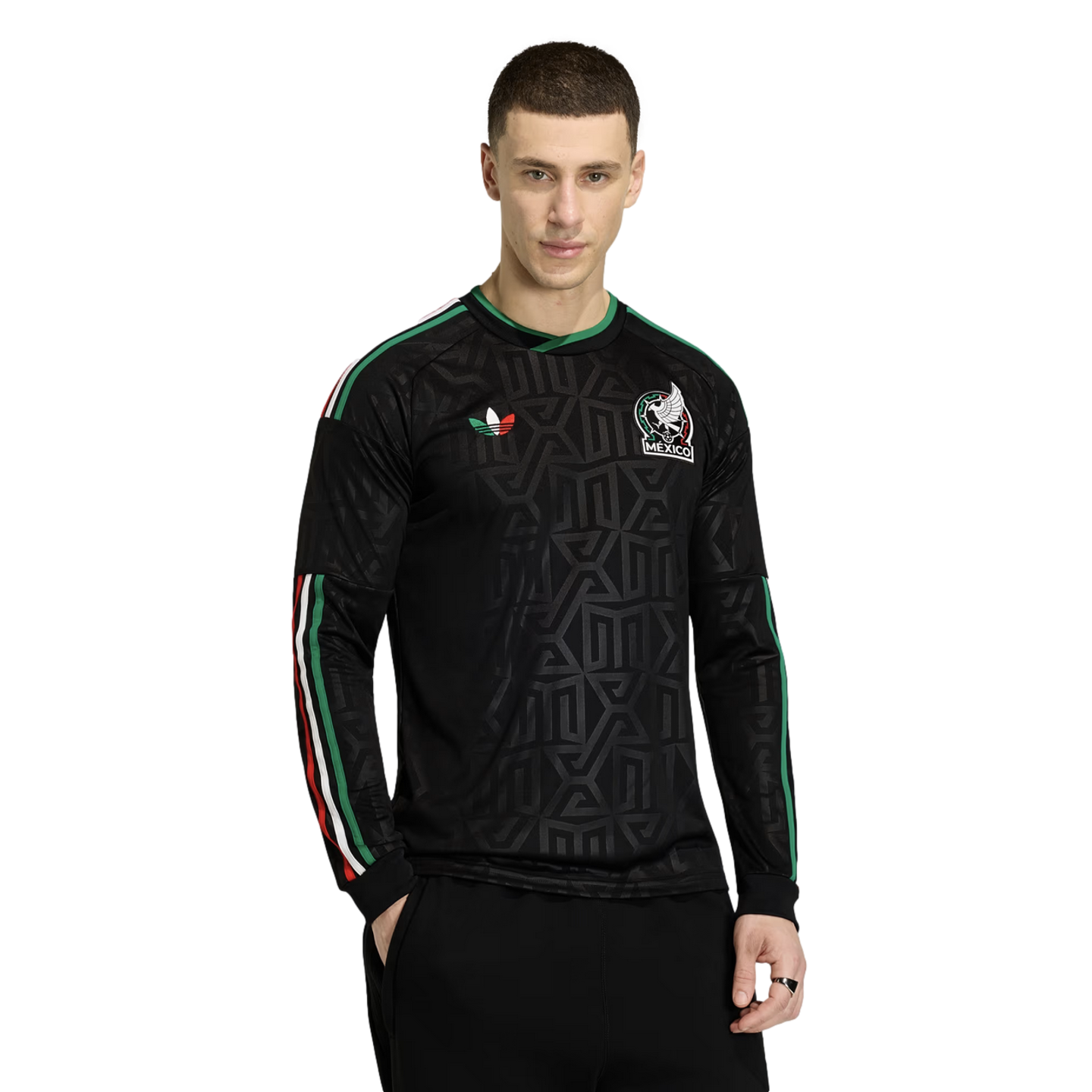 A man in a black long-sleeve Mexico national team jersey with a geometric pattern, green-white-red accents, and an eagle crest, posed against a white background.